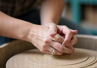 Hands working on a pottery wheel during a workshop